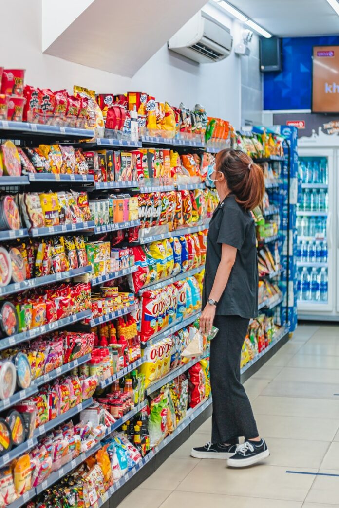 Photo by Khuc Le Thanh Danh a woman standing in front of a display of food