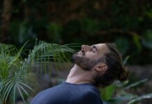 운동으로 스트레스 해소하기: 건강한 마음과 몸을 위한 가이드 a man sitting on a yoga mat in the middle of a forest