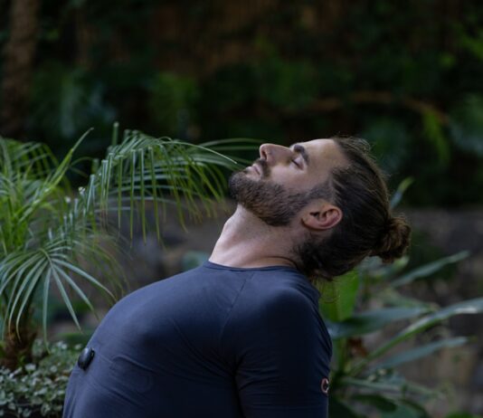 운동으로 스트레스 해소하기: 건강한 마음과 몸을 위한 가이드 a man sitting on a yoga mat in the middle of a forest