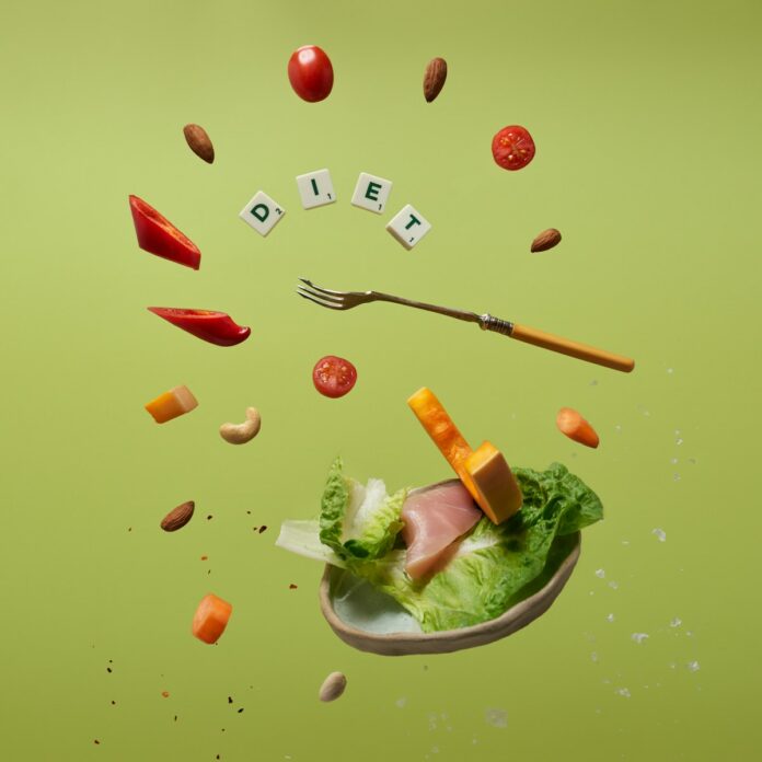 Photo by Tangerine Newt a piece of lettuce, carrots, tomatoes, and a fork are