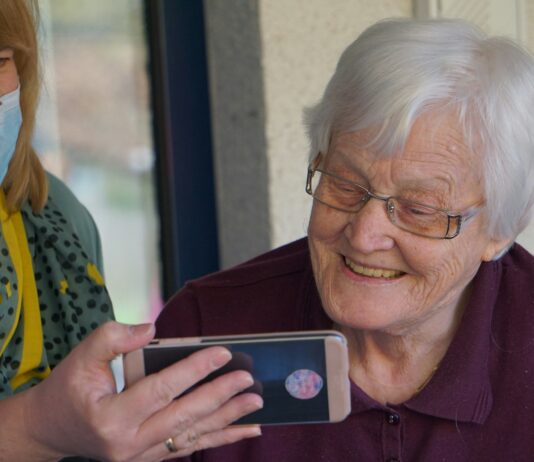 장기요양 재택의료센터 시범사업 확대 운영 woman in brown button up shirt holding white smartphone