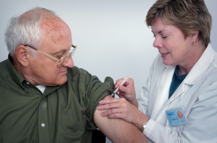 Photo by CDC woman injecting syringe on mans arm