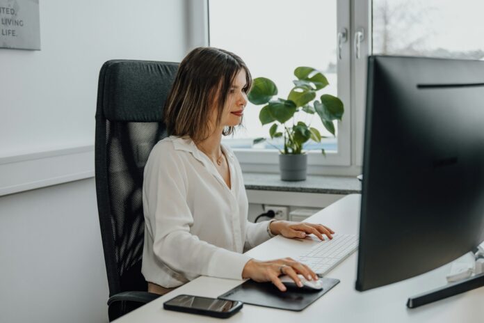 Photo by SEO Galaxy a woman sitting at a desk using a computer
