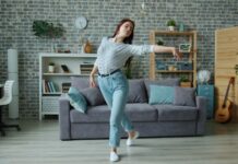 늘어나는 집콕 생활, 건강 지키는 ‘홈 웰니스’ 습관이 뜬다 Young woman dancing in a modern living room.