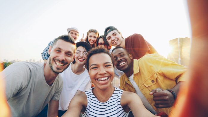 Photo by Vitaly Gariev A diverse group of friends taking a selfie outdoors